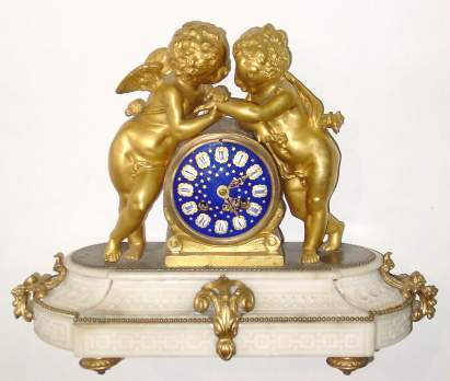 C.1860, Ormolu and white marble mantel clock, figures of an infant holding hands with a putti, Cupid, come to console him, both looking loving and pensive at the same time, the clock with a superior cobalt blue dial with gold stars and white numeral shields with black Roman numerals. — Antique Clocks Price Guide