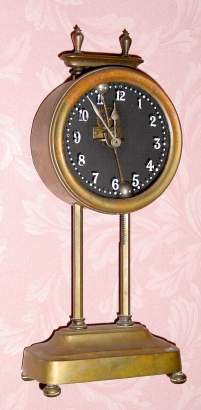 C.l921, English Gravity timepiece 30-hour movement is driven by its own weight to be raised each day along a tooth upright, with a visible escapement and a compound bar-bell pendulum. — Antique Clocks Price Guide