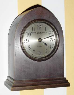 C.1925 Chelsea Clock Co., Boston. Mass., "Gothic", 8-day desk timepiece with the serial no. 169240 retailed by Bigelow, Kennard and Co., Inc., Boston in a polished bronze or red brass case. — Antique Clocks Price Guide