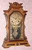  C.1885, E. Ingraham and Co., "FAULTLESS" , 8-Day time and strike gingerbread clock, in a two tone maple case with ebonized accents. 