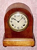  C.1917, Waterbury Clock Co., Birch cased price leader Round Gothic mantel clock, 8-day time and strike. 