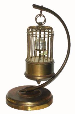 C.1950, German, I. Kaiser Gmgh, Villingen, Bird in Cage, on Stand, with alarm, the time indicated on annular rings (bottom for hours, top for minutes), a separate dial in the floor of the cage for the alarm, and with a twitching bird that moves when clock ticks. — Antique Clocks Price Guide