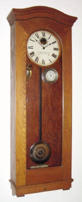 C.1910, Standard Electric Clock Co., Springfield, Mass, master regulator from a school, oak cased with damascene pendulum and pilot clock. — Antique Clocks Price Guide