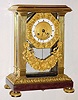 C.1840, French, Empire style 4-glass, the movement suspended between front 2 columns, glass around and on other 3 sides, and with a floral spray beneath. 
