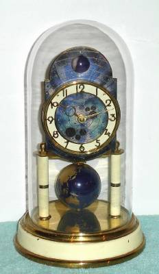 C.1954, J. Kaiser, G.M.B.H. 400-day timepiece with a moon phase dial, and terrestrial globe pendulum. — Antique Clocks Price Guide