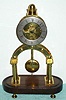 C.1870, French, small skeleton timepiece, on an oval wooden base, no dome. 
