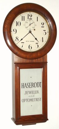 C.1915, Seth Thomas "Regulator No. 2", 8-day wall clock in a mahogany case, with advertising glass for Haserodt, Optometrist and Jeweler, black and white. — Antique Clocks Price Guide