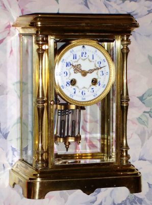 C.1900, French, Japy Freres, Crystal Regulator, in a brass case with full standing columns at the front corners; a cream colored dial with polychrome floral decorations and a 2-vial compensating pendulum. — Antique Clocks Price Guide