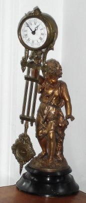 C.1890, French, Small Swinger, or mystery swinging timepiece, foot long clock arm suspended on a child in a dress. Dial of clock = 2", rear wind. — Antique Clocks Price Guide