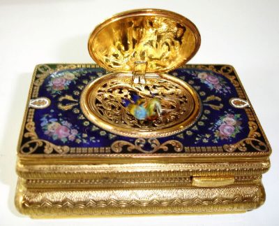 Late 20th Century, German, Singing Bird box, key wound, in an engraved and gilded case with enamel top showing floral decorations and the bird cover with a garden scene with lovers. — Antique Clocks Price Guide
