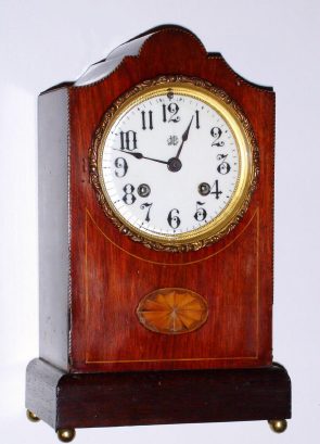 C.1900, Vermont Clock Co., Fairhaven, VT, mahogany cased mantel clock, 8-day time and gong strike, case with cross banded edge inlay and a central fan, possibly cased by Jennings Brothers whose logo is on dial.. — Antique Clocks Price Guide