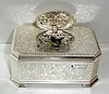 Late 20 the Century, German, Singing Bird box, in a silver plate over embossed brass case, with a mechanical key wound bird singing at will, when front slide is pushed to the right. 