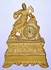 C.1840, French, Ormolu Figural Clock, Asian Motif, a lady clad in ceremonial dress with small pointy shoes, her braided hair rolled on top of her head, and with small blossoms in her hair, with a feather fan in her hand, the frieze below the lady with two pagodas or temples, each with a hanging bell, and little bells cast into the edge of the case all round the center and the base. 