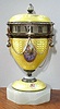 C.1890, Swiss/Austrian, Mini "Egg" on marble base, with a small stem wind 1-day movement, and with 6 mini cherubs in ovals applied to the yellow Guilloche enamel over silver. A 7th cameo below the indicator of a lady in a violet colored dress. 
