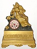 C.1860 French Ormolu Figural Clock: Clock has a colored porcelain dial with a figure of a maiden seated with a dove giving her a peck on the cheek, and an 8-day time and bell strike movement. 