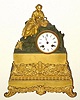 C.1860 French Ormolu Figural Clock: Clock has a porcelain dial with a figure of a woman seated with a picnic basket and an 8-day time and strike movement. 