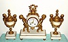 C.1890, French, 3-Piece Mantle Clock Set, of marble and white metal with gold patination, the clock being held by two cherubs and the garnitures each with a pair of winged cherubs. 