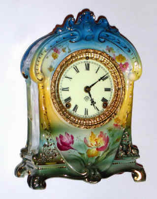 C.1904, Ansonia, Royal Bonn, "La Cruz" porcelain china clock, in a tri-color case starting at dark aqua to top down to yellow in the center, and green at the base. With solid porcelain dial. See 1998 Ansonia book page 632, fig 2687, 2004 price guide = $500. — Antique Clocks Price Guide