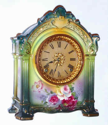 C.1914, Ansonia, Royal Bonn, "La Savoie" porcelain china clock, in a tri-color case, dark aqua to top, next yellow and a base of dark green; plus colorful floral decorations on the top and sides. — Antique Clocks Price Guide