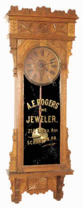 C.1900, Wm. L. Gilbert, SALISBURY, highly decorative oak cased wall clock, with original advertising glass for A. E. Rogers, The Jeweler, 215 Lackawanna Ave, Scranton, PA, — Antique Clocks Price Guide