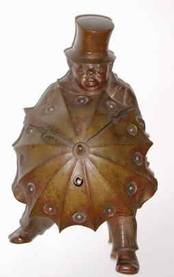 C.1900, French, Novelty figural timepiece, a detailed bronze casting of a portly Englishman in top hat, holding his umbrella against the wind, and the clock hands, 8-day, platform mov't. — Antique Clocks Price Guide