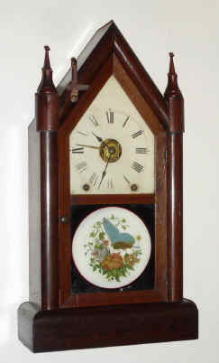 C.1879, Seth Thomas Clock Co., "Sharp Gothic", 8-day time/strike/ special alarm steeple clock. This clock is fitted with an early version of Winward's new eight-day railway "alarum". The strange lever on the upper left side of the case was used to silence the alarm. The strike train is used to activate the alarm, rather than the use of a separate movement. — Antique Clocks Price Guide
