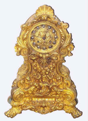 C.1830, French, Guyerdet Aine, Paris, rococo style gilt bronze figural clock, the case profusely decorated with shells and fruit and with lions paw feet, the well made silk thread susp movement signed by the maker, struck over the Pons-1827 award medallion. — Antique Clocks Price Guide
