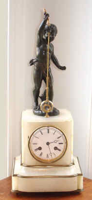 C.1880, French, Farret a' Paris, Bronze and white marble MYSTERY clock, the movement with a steel arm over the verge, near the top case panel, which is moved from side to side by a strong magnet in the bottom of the pendulum, which attraction for the steel pulls the pendulum toward the center and results in a 'scape at the same time. A small brass counter weight brings the verge back to center and gets it ready for the next impulse from the other direction. The bronze figure signed Ferrand. — Antique Clocks Price Guide