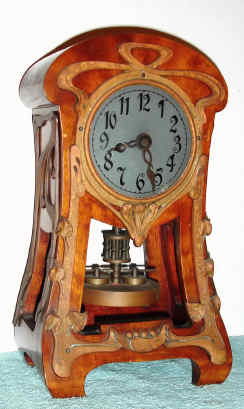 C.1905, German, Jahresuhrenfabrik, Model 218, Art Nouveau timepiece in a cherry case with copper colored brass cast decorations both front and sides, and with disc pendulum. — Antique Clocks Price Guide
