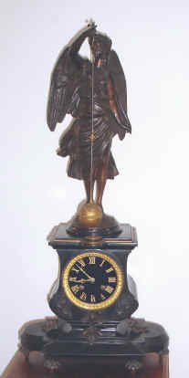 C.1880, French, Conical Pendulum Clock, the base of bronze and Belgian black slate, and the angel statue of patinated spelter, holding a detailed cast and gilded globe as the pendulum, signs of the Zodiac around the equator. — Antique Clocks Price Guide