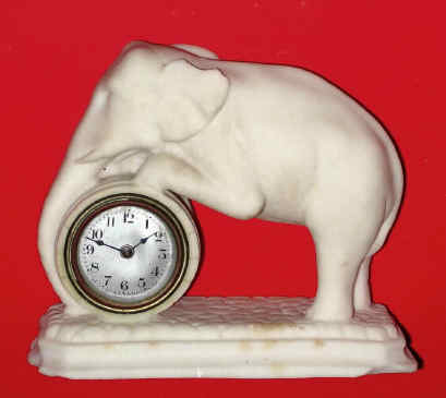 C.1900, Lux Clock Mfg Co., Waterbury, Conn, ELEPHANT novelty, the clock set into a parian figure of an elephant pushing a barrel. — Antique Clocks Price Guide