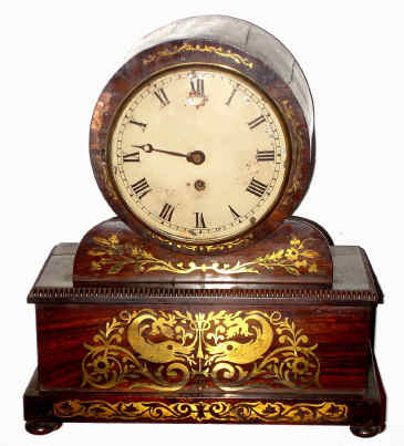 C.1820, English, Drum Head single fusee timepiece with an uncommon round movement, rosewood case with inlaid dolphins and flowers, locking rear access door. — Antique Clocks Price Guide