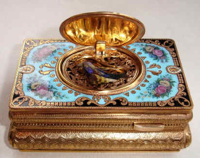 Late 20th Century, German/Swiss, singing bird box with enameled scene on the cover of a gentleman presenting a gift to a lady in pastoral setting, the surround in aqua colored enamel accented with yellow and pink roses. — Antique Clocks Price Guide