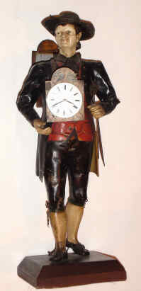 C.1900, German, CLOCK PEDDLER, now with key-wind Swiss watch movement and dial, figure in original paint, the peddler with a group of pendulums in his left hand. Entire statue is carefully formed segments of tin, soldered together and painted. — Antique Clocks Price Guide