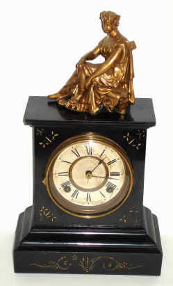 C.1900, Ansonia, Enameled Iron mantel clock with gold painted decorative figure. — Antique Clocks Price Guide