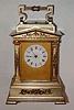 C.1890, French, Brass Cased Carriage clock, in a large architectural case w/ pediment top, with tu-tone gilding, each corner with square columns and Corinthian capitals on each, dentil molding all 'round the top and cast floral decorations below the roof line, and on all 4 sides of the base; time, strike and repeat, 8-day with original platform.
