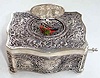 Late 20th Century, German/Swiss, singing bird in a .925 marked coin silver case, embossed with cherubs and birds, and the lid decorated with two putti, one with lyre, the second with music book.