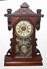 C.1891, Waterbury Clock Co., JENNER, walnut cased gingerbread clock, 8-day gong strike with alarm.