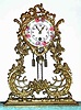 C.1930 German, 30-hour porcelain face, key wind, pendulum timepiece mounted in a brass plated spelter filigree case.