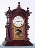 Mixed lot, C.1880 Welch "Patti" rosewood case, now with a C.1910 large kitchen style movement, 8-day, installed onto a piece of pressed board, added to bring the minute shaft out to the correct length.