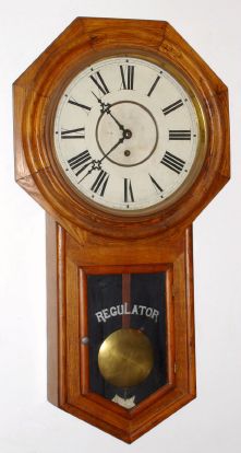 Waterbury Clock Co., CONSORT model, long drop octagon school clock, time only, in oak. C.1906. — Antique Clocks Price Guide