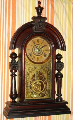 Ansonia Clock Co, Ansonia Conn. "KING" model, 8-day brass time and strike and alarm movement in black walnut case with carved lion topped tapered full round fluted columns, spring driven. C. 1880. — Antique Clocks Price Guide