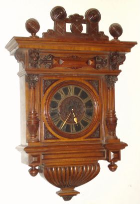 Austrian, Walnut cartel clock, silk thread suspension, signed Johann Kriwsky, with a brass cut out chapter ring over a wooden dial plate, large 8-day movement, gong strike, spring. The walnut case with deeply carved 3/4 columns and with finely detailed lions above. C.1875. — Antique Clocks Price Guide