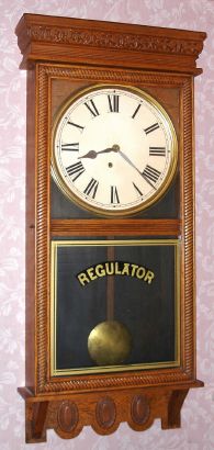 E. Ingraham and Co, Bristol Conn, "NORTHWESTERN" model, 8 day time only brass mvt store regulator in solid oak case with 12" dial, spring driven. C. 1910. — Antique Clocks Price Guide