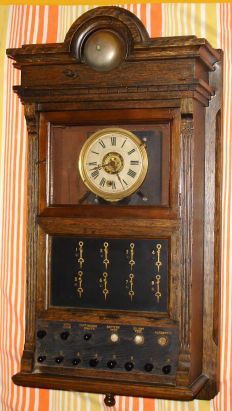 E. Ingraham and Co, Bristol, Conn, movement in a hotel burglar alarm clock with electrical components, spring driven time brass mvt with alarm function. Below dial are eight indicators covering zones or rooms in the alarm system and silent and battery test features in heavy walnut case with outer alarm bell set on top of case in crest. C. 1920. — Antique Clocks Price Guide