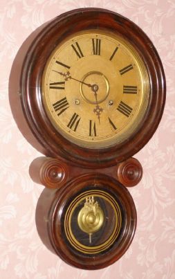 E. Ingraham and Co., "IONIC", figure 8 time and strike wall clock in a grained case. C.1911. — Antique Clocks Price Guide