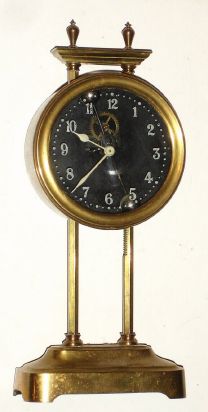 French, Gravity Clock, 1-Day, with exposed compound pendulum visible through the glass dial; movement in a brass canister that is raised on toothed upright to wind. C.1922. — Antique Clocks Price Guide