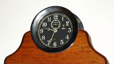 Chelsea Clock Co., Engine Room timepiece, with 4.5" Black Dial, serial No. 120602, in a nickel finish brass case with screw bezel, on a later oak stand. C.1917. — Antique Clocks Price Guide