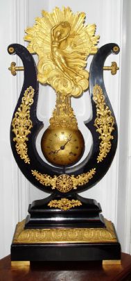 French, ebony lyre pinwheel, the movement contained in a brass globe, flattened in the front to allow for the dial, and the entire assembly swinging as a pendulum, the crutch extending from the bottom of the movement and engaging a vernier beat set thumb screw. — Antique Clocks Price Guide
