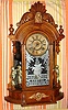 Ansonia Clock Company, Ansonia Conn. "TRIUMPH" model, 8-day brass time and strike mvt in oak mirror-sided case flanked by two cupids shelf clock, spring driven. C. 1880.